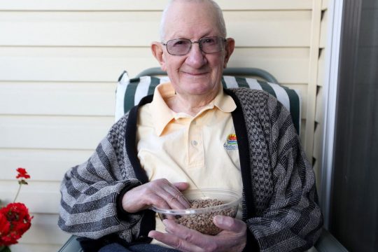 Famous senior man holding bowl of lentils